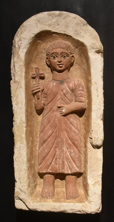 Egyptian youth framed by niche with a round arch, Coptic limestone tomb stele from Antinoupolis, 4th